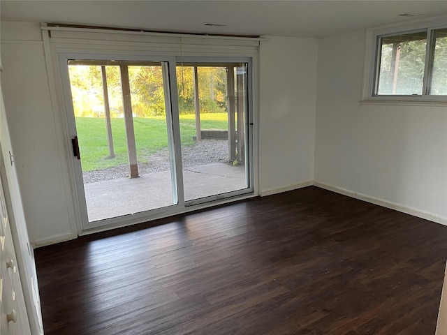 unfurnished room featuring baseboards and dark wood finished floors