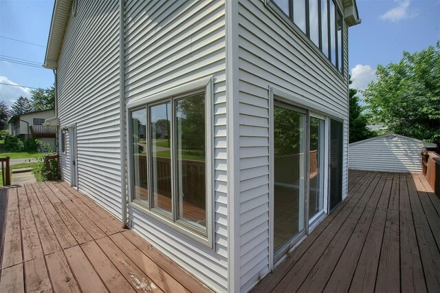 wooden terrace with a storage shed and an outdoor structure