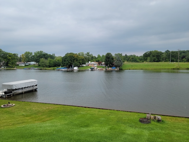 property view of water with an outdoor fire pit and a boat dock