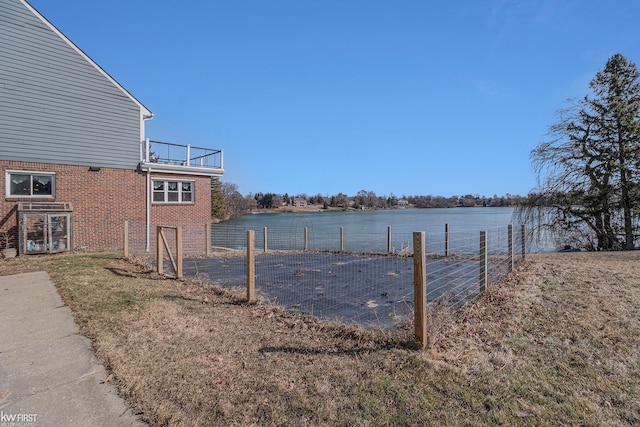 exterior space with a water view and fence