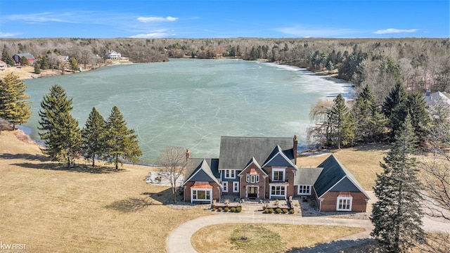 birds eye view of property featuring a wooded view and a water view