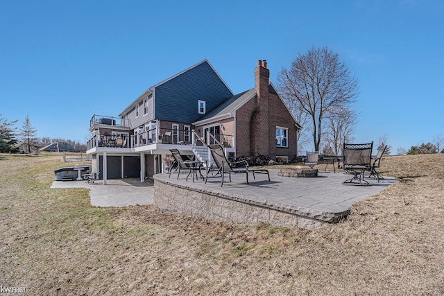 rear view of property featuring a deck, a patio, an outdoor fire pit, stairway, and a chimney