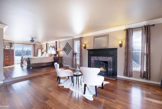 interior space with crown molding, wood finished floors, baseboards, and a high end fireplace