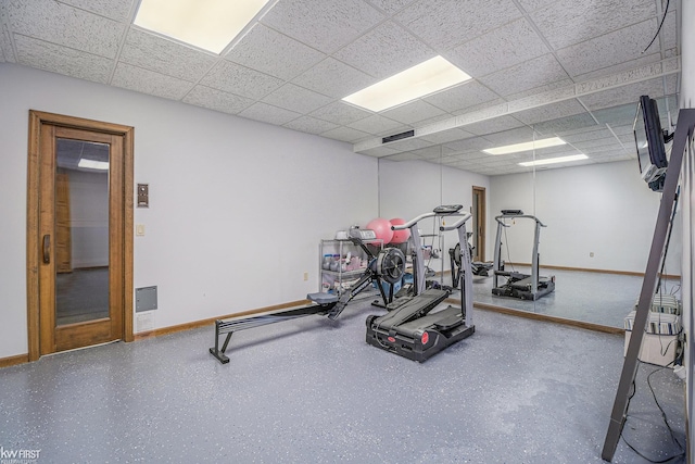 exercise area featuring a drop ceiling and baseboards