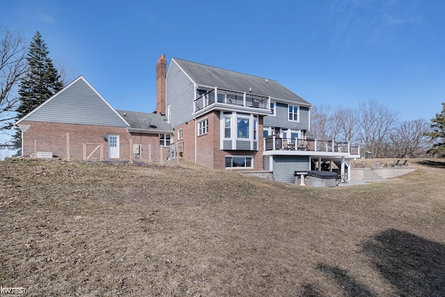 back of house with brick siding, a balcony, a chimney, and a patio area