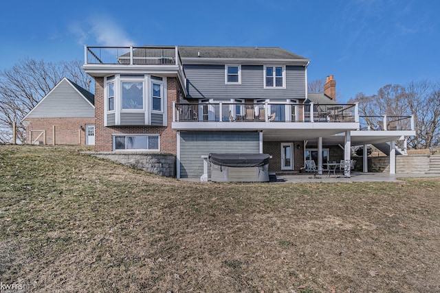 back of property featuring a patio area, a yard, a hot tub, and brick siding