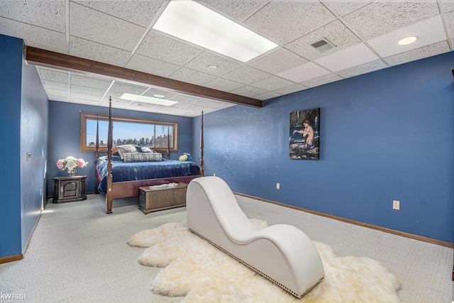 carpeted bedroom with visible vents, baseboards, and a drop ceiling