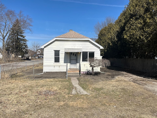 view of front of house featuring a shingled roof and fence