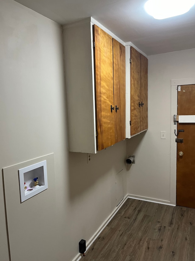 washroom with dark wood finished floors, cabinet space, baseboards, and washer hookup