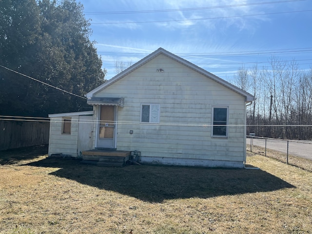 back of property with fence and a lawn