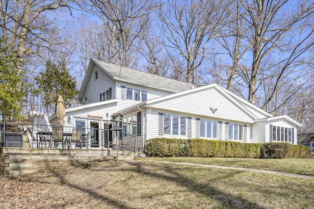 view of side of home with a deck and a yard