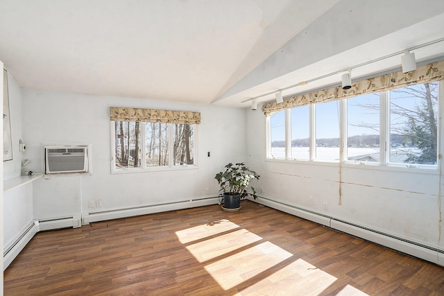 unfurnished room featuring vaulted ceiling, a wall mounted air conditioner, a baseboard heating unit, and wood finished floors