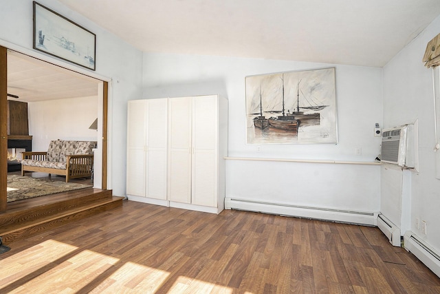 interior space with a baseboard radiator, wood finished floors, and vaulted ceiling