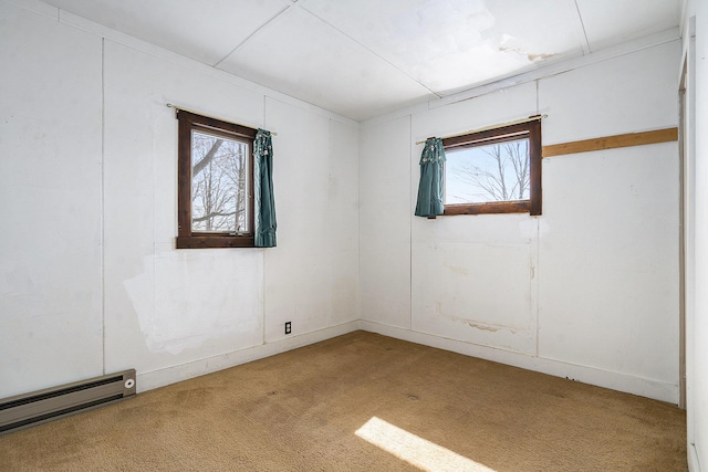 spare room featuring a baseboard heating unit and carpet flooring