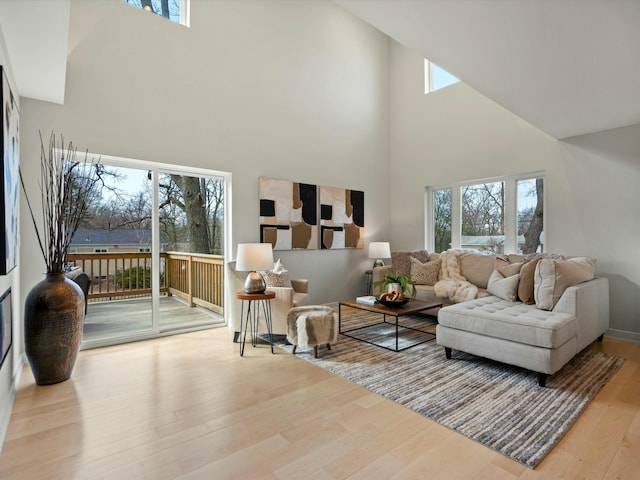 living room featuring a towering ceiling and wood finished floors