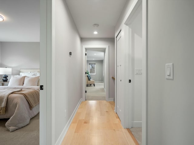 hall featuring baseboards and light wood-style floors