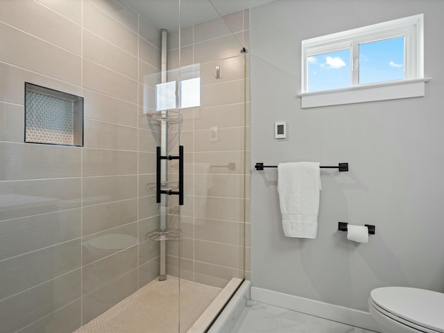 full bathroom featuring marble finish floor, toilet, tiled shower, and baseboards