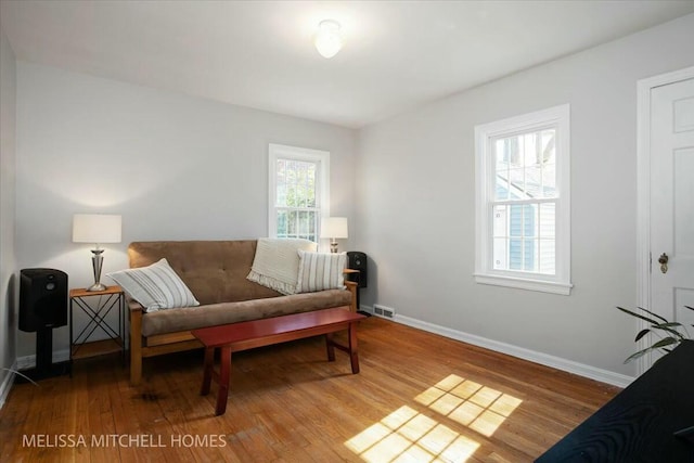 sitting room with visible vents, wood finished floors, and baseboards