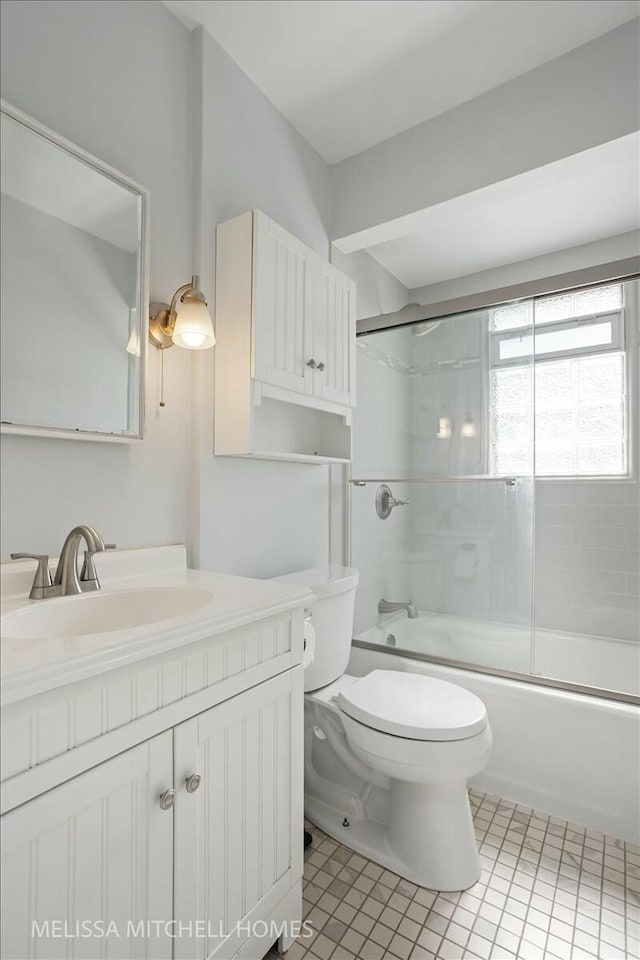 full bath with enclosed tub / shower combo, toilet, vanity, and tile patterned flooring