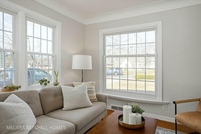 living room with visible vents, baseboards, a healthy amount of sunlight, and wood finished floors