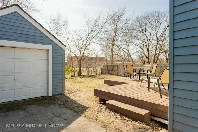 view of yard featuring an outbuilding, outdoor dining area, a deck, and fence