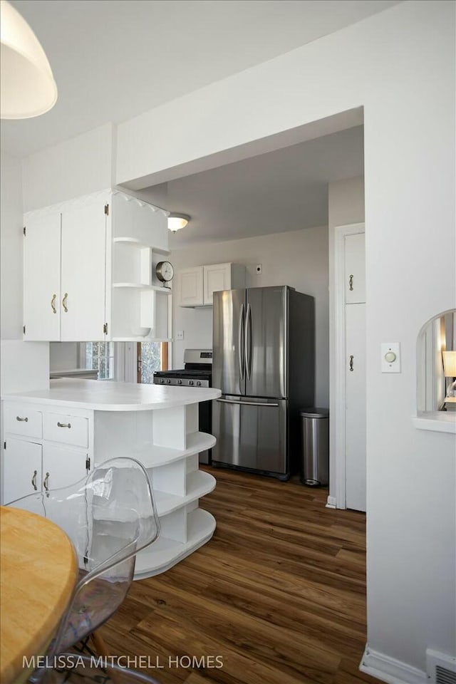 kitchen featuring white cabinetry, stainless steel appliances, a peninsula, and open shelves