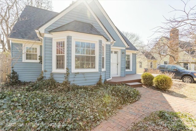 bungalow-style home with roof with shingles