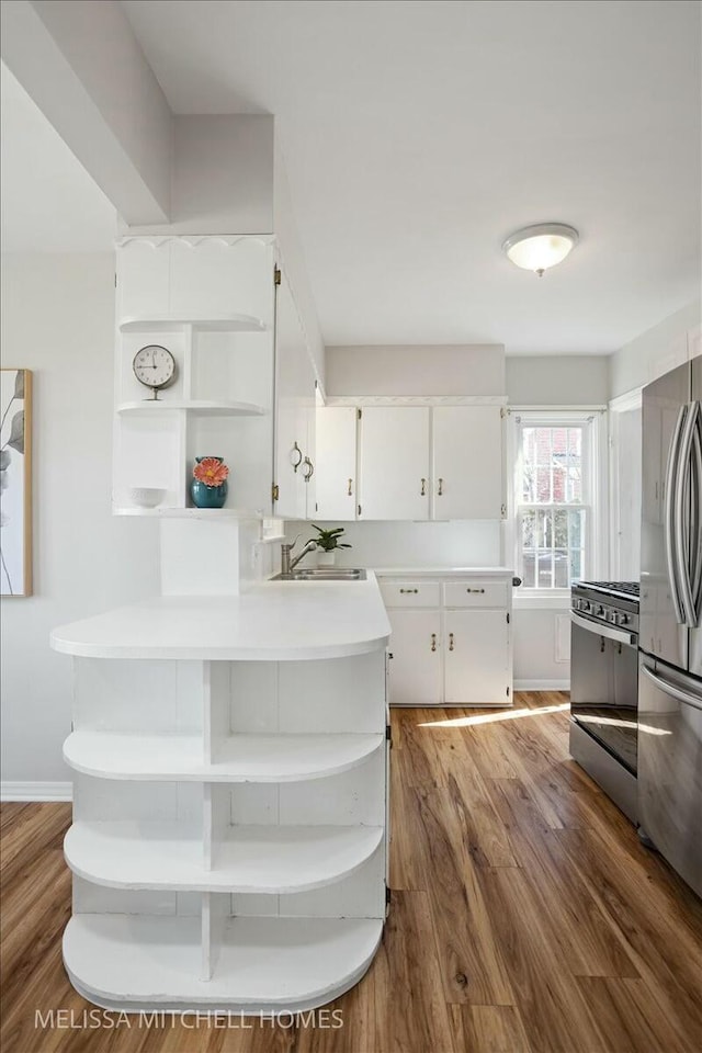 kitchen featuring a sink, stainless steel appliances, dark wood-type flooring, and open shelves