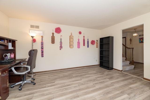 office space with baseboards, visible vents, and light wood finished floors