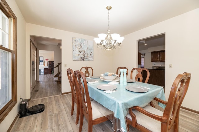 dining space with stairs, light wood-type flooring, and baseboards