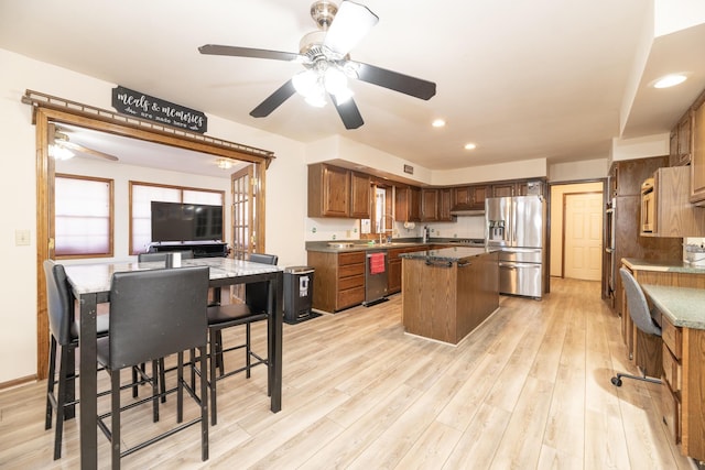 kitchen featuring light wood-type flooring, under cabinet range hood, a kitchen island, recessed lighting, and appliances with stainless steel finishes