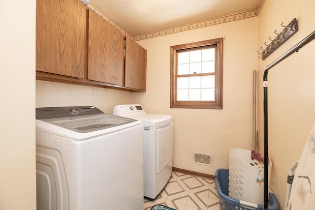 laundry room with washing machine and clothes dryer, visible vents, baseboards, light floors, and cabinet space