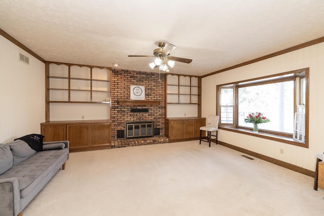 living area featuring carpet flooring, a fireplace, visible vents, and ornamental molding