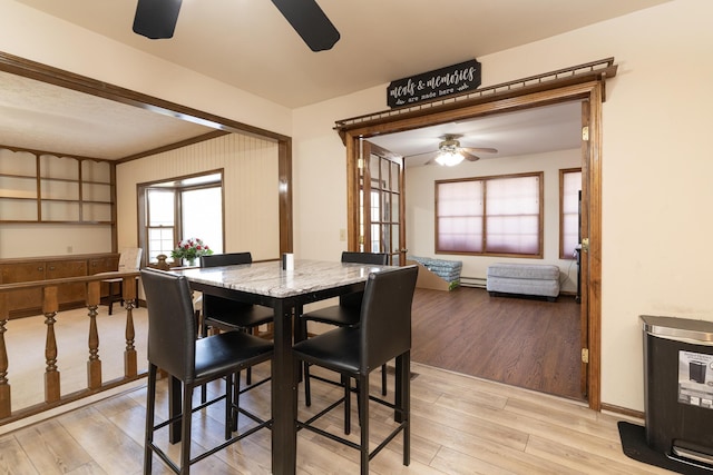 dining room with baseboards, light wood-style floors, and a ceiling fan