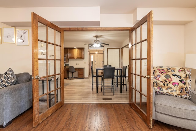 living area featuring french doors, wood finished floors, and a ceiling fan