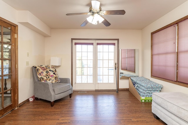 living area featuring a ceiling fan, wood finished floors, and baseboards