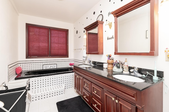 bathroom featuring tile patterned floors, a bath, double vanity, and a sink