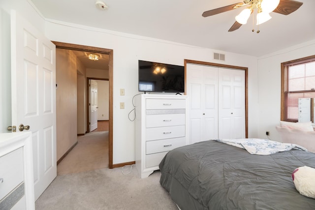 bedroom featuring visible vents, baseboards, light carpet, a closet, and a ceiling fan