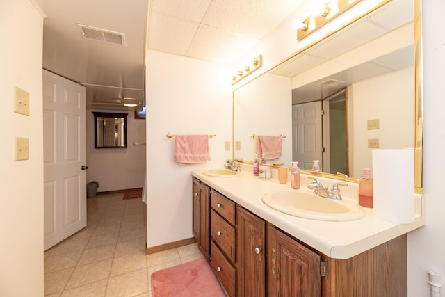 full bathroom with a sink, visible vents, double vanity, and tile patterned flooring