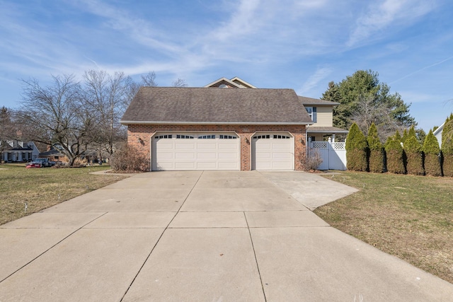 view of front of property featuring brick siding, an attached garage, fence, a front yard, and driveway