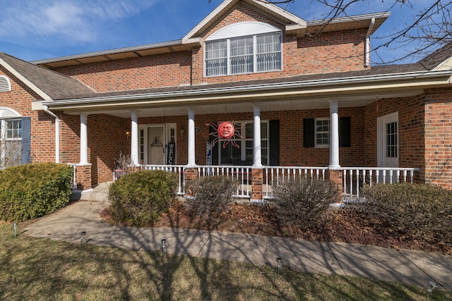 traditional-style house featuring brick siding and covered porch