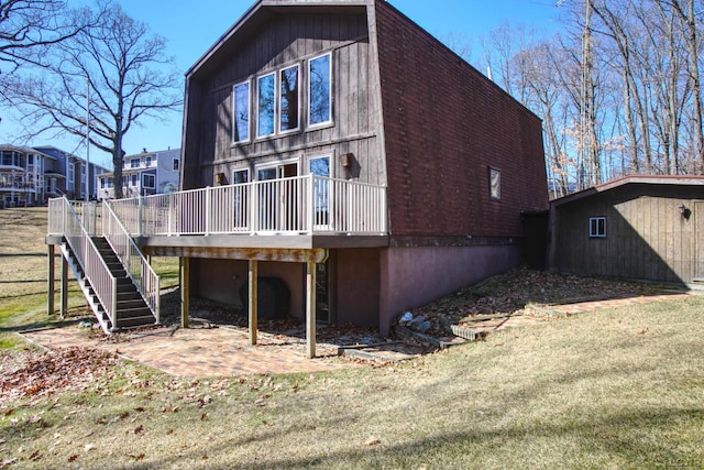 back of property with stairs, a deck, and a lawn