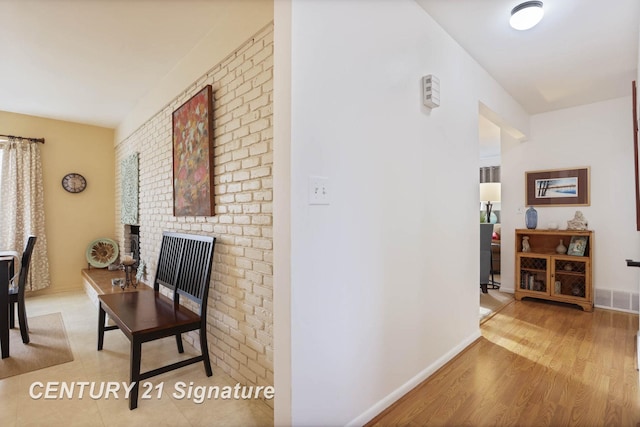 corridor with visible vents, baseboards, and wood finished floors