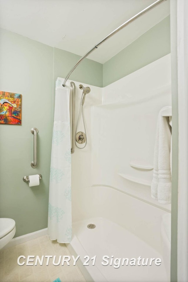 full bathroom featuring tile patterned flooring, curtained shower, toilet, and baseboards