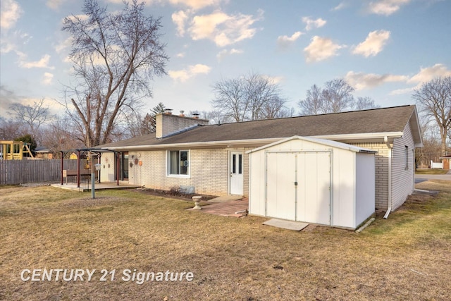 back of house with an outbuilding, a yard, a chimney, a storage shed, and brick siding