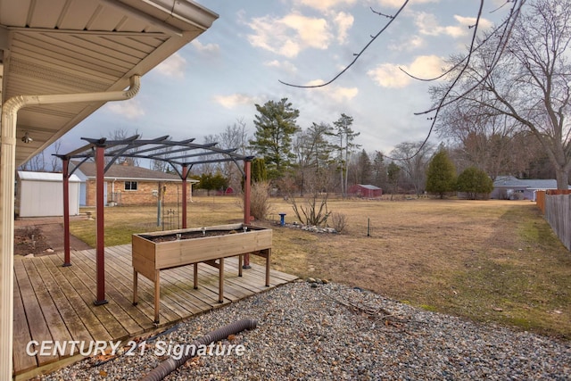 view of yard featuring an outbuilding, a pergola, a storage shed, and fence