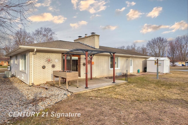 back of property featuring an outbuilding, central AC, a chimney, a storage unit, and brick siding