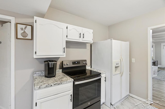 kitchen featuring electric stove, white cabinetry, white fridge with ice dispenser, baseboards, and light stone countertops