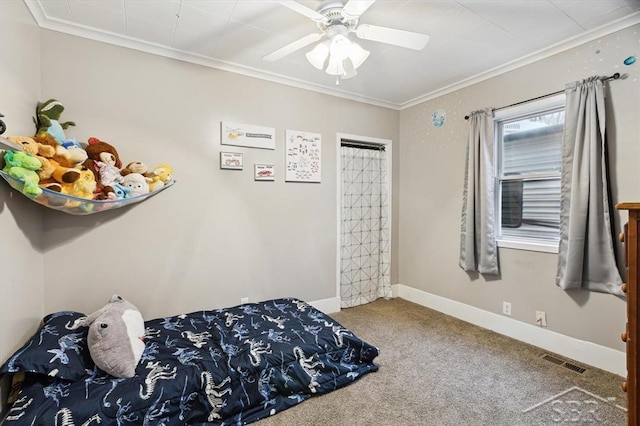 carpeted bedroom featuring visible vents, baseboards, a ceiling fan, and crown molding