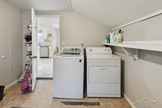 laundry area featuring baseboards, laundry area, and washing machine and clothes dryer